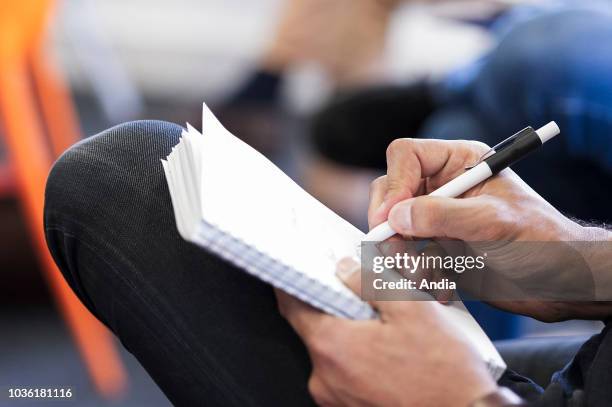 Note-taking on a pice of sheet with a pen during a business meeting