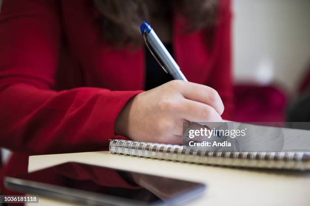 Note-taking on a pice of sheet with a pen during a business meeting