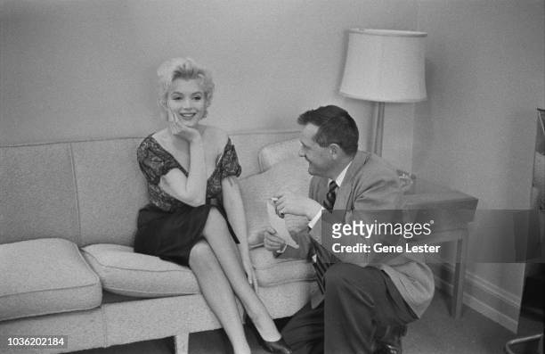 American actress Marilyn Monroe with a reporter during a press call to publicise her latest film, Joshua Logan's 'Bus Stop', 1956.