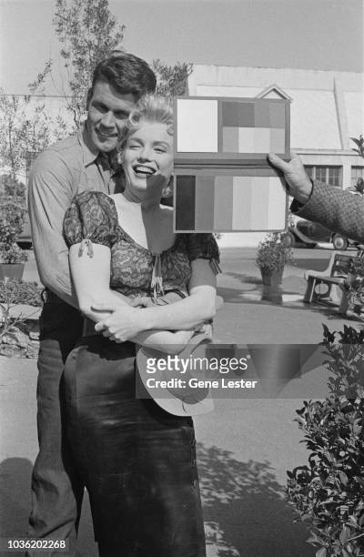 American actress Marilyn Monroe preparing to pose with co-star Don Murray, during a press call to publicise, Joshua Logan's 'Bus Stop', 1956.