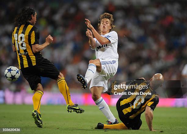 Sergio Canales of Real Madrid is tackled by Guillermo Rodriguez and Marcelo Sosa of Penarol during the Santiago Bernabeu Trophy match between Real...