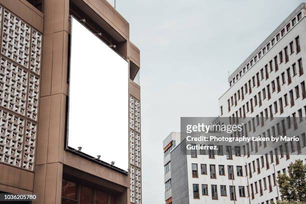 blank billboard on building facade - placard stock-fotos und bilder
