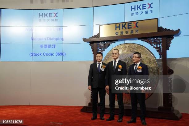 Wang Xing, chairman, chief executive officer and co-founder of Meituan Dianping, center, Mu Rongjun, senior vice president and co-founder, left, and...