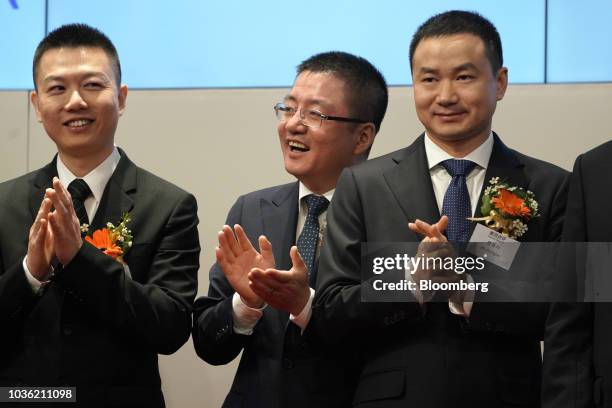 Wang Huiwen, senior vice president and co-founder of Meituan Dianping, center, and Mu Rongjun, senior vice president and co-founder, right, applaud...