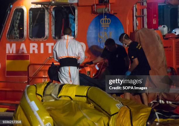Rescue workers carry the corpse of a migrant, rescued together with a group of migrants of a dinghy on the Mediterranean Sea, after they arriving at...