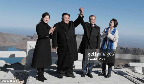 North Korean leader Kim Jong Un and his wife Ri Sol Ju pose with South Korean President Moon Jae-in and his wife Kim Jung-sook on the top of Mount...