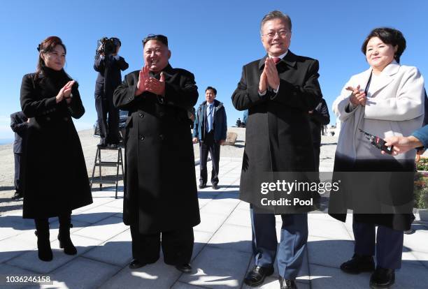 North Korean leader Kim Jong Un and his wife Ri Sol Ju applaud with South Korean President Moon Jae-in and his wife Kim Jung-sook as they arrive at...