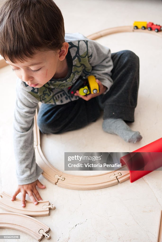 Boy playing with wooden toy train