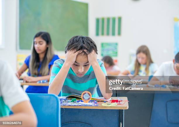 boy overwhelmed from learning electronics for stem - adhd child imagens e fotografias de stock