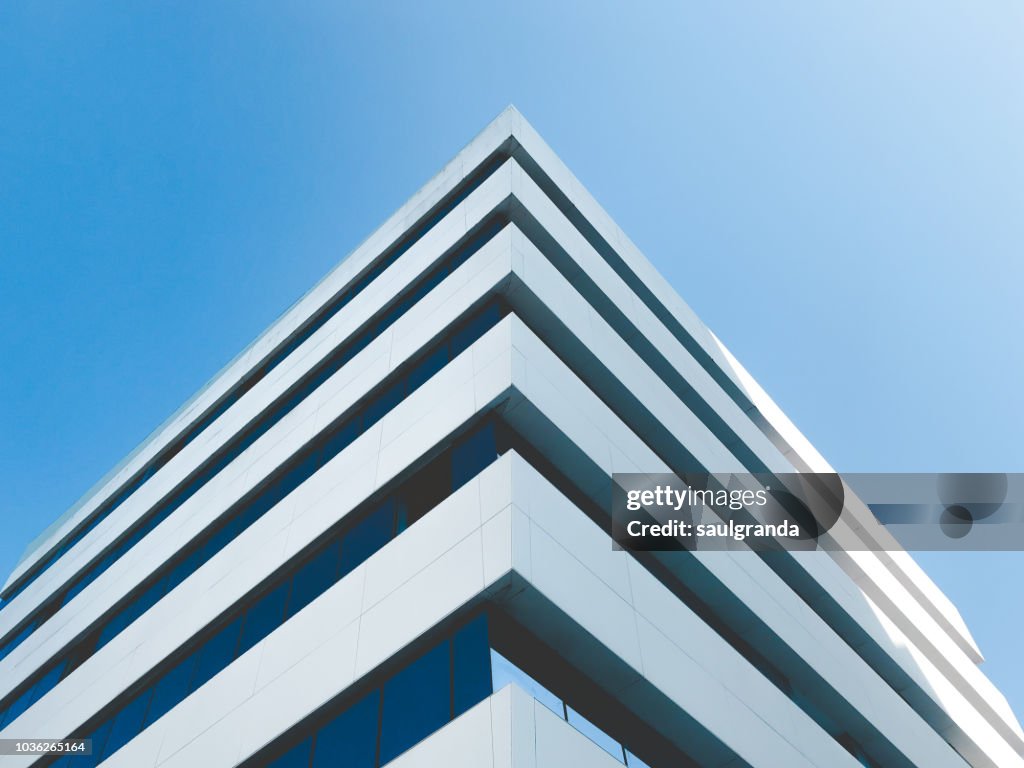 Low angle view of building corner against clear blue sky