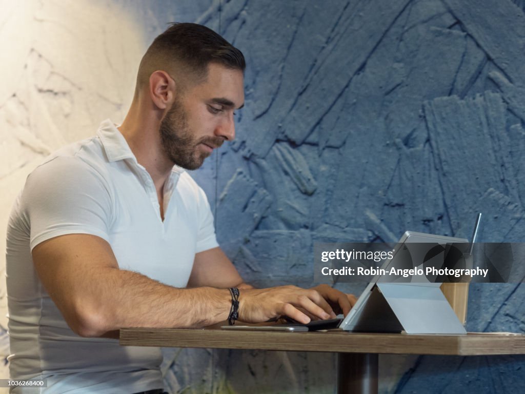 A man working on his laptop in a café