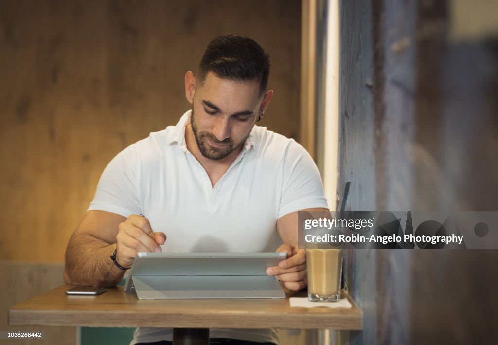 A man working on his laptop in a café