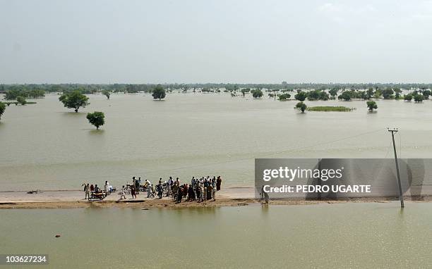 Pakistanis affected by the floods stand in a road in Shah Jamaal village in the district of Muzaffarragh in Punjab on August 22, 2010. UN agencies...