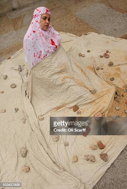 Woman from the 'Anglo Iranian Women Association' stages a mock demonstration of a stoning on Whitehall on August 25, 2010 in London, England. The...