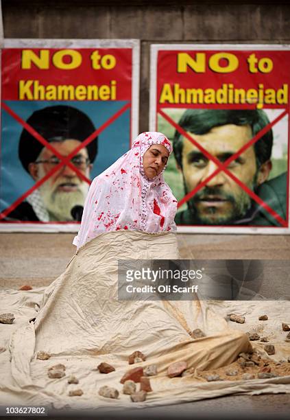 Woman from the 'Anglo Iranian Women Association' stages a mock demonstration of a stoning on Whitehall on August 25, 2010 in London, England. The...