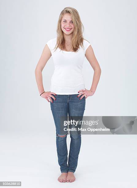 smiling young female with hands on her hips - jeans barefoot fotografías e imágenes de stock