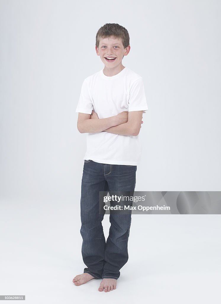 Young boy laughing with arms crossed