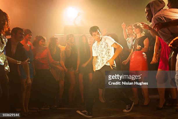 a break dancer surrounded by crowd at a club - street dance stock pictures, royalty-free photos & images