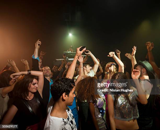 people dancing in crowded night club - ocio fotografías e imágenes de stock