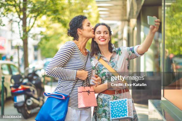 mother and adult daughter are taking selfies outdoors - fashionable mom stock pictures, royalty-free photos & images