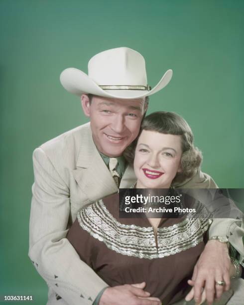 Singer and actor Roy Rogers and his wife Dale Evans pictured smiling with Rogers seated behind his wife with his arms around her USA, circa 1955.