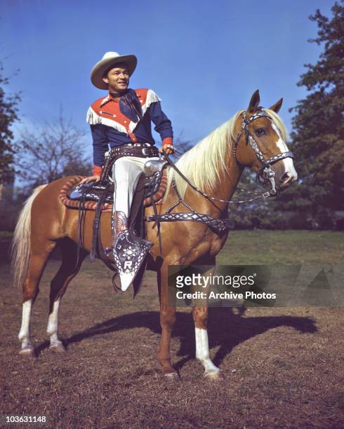 Singer and actor Roy Rogers pictured astride his palomino horse, Trigger, USA, circa 1945. Rogers is wearing a costume of red, white and blue.