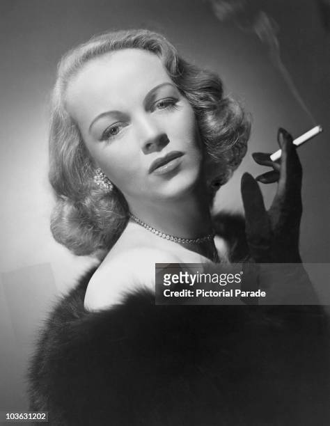 Actress Maria Riva pictured smoking a cigarette held in her black gloved hand, USA, circa 1950. Riva is the daughter of the actress Marlene Dietrich.