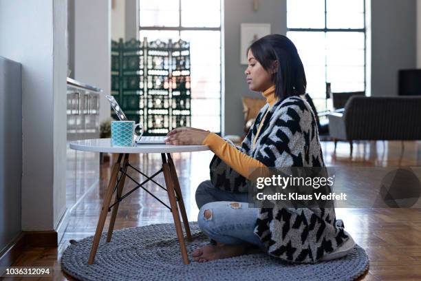 young woman working from home on laptop - sitting on floor fotografías e imágenes de stock