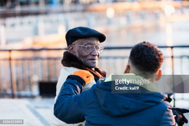 Senior African-American man sitting with great grandson