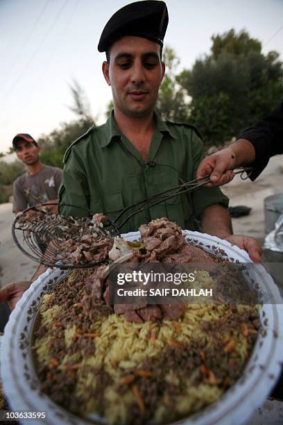 Palestinian security forces prepare to break their day-long Ramadan fast over a group "Iftar" meal of traditional Mansaf , at the police headquarters...