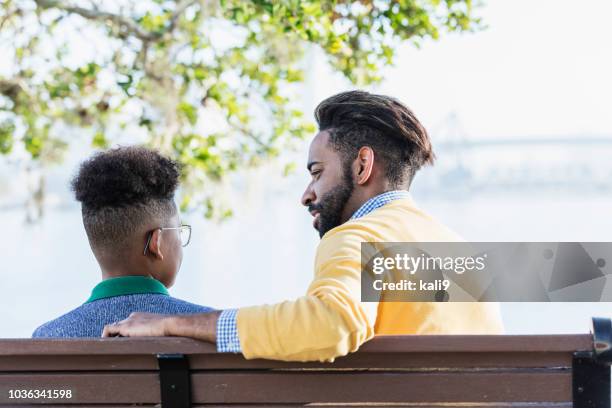 mixed race father and teenage son city on waterfront - serious teenager boy stock pictures, royalty-free photos & images