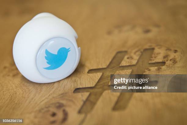 Gadget with the logo of social media service Twitter are seen on a table with an engraved hashtag sign in a conference room at the Twitter office in...