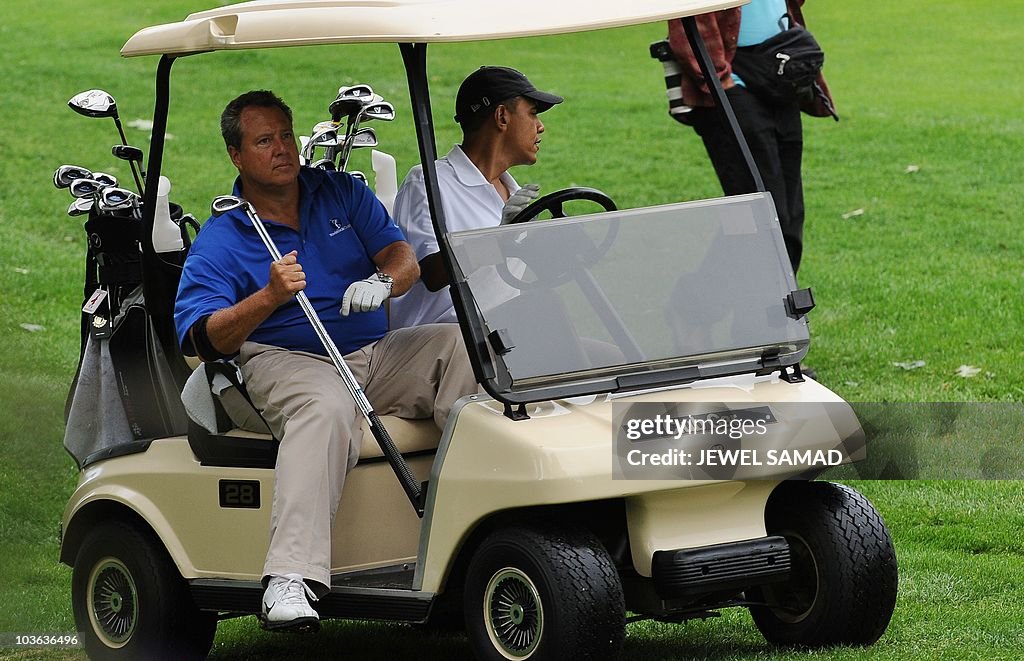 US President Barack Obama drives a golf