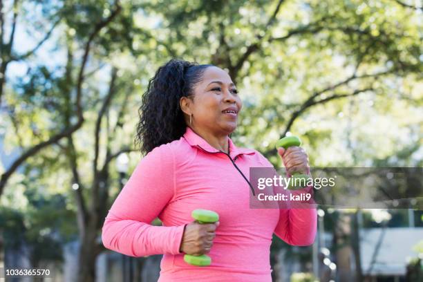 african-american woman powerwalking with hand weights - speed walking stock pictures, royalty-free photos & images