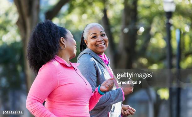 maduras mujeres afroamericanas en la ciudad, ejercicio - two woman running fotografías e imágenes de stock