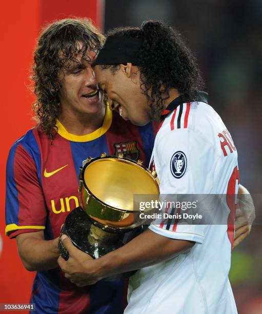 Carles Puyol of Barcelona chats with his former teammate Ronaldinho of AC Milan after the Joan Gamper Trophy match between Barcelona and AC Milan at...