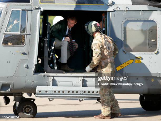 Prince Harry, Duke of Sussex disembarks a Royal Navy Wildcat Maritime Attack Helicopter as he arrives for a visit to The Royal Marines Commando...