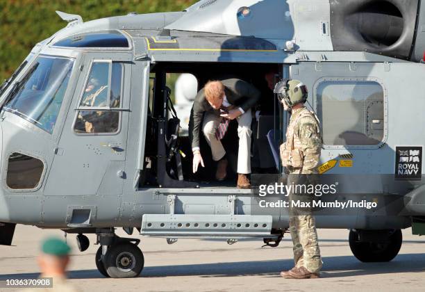Prince Harry, Duke of Sussex disembarks a Royal Navy Wildcat Maritime Attack Helicopter as he arrives for a visit to The Royal Marines Commando...