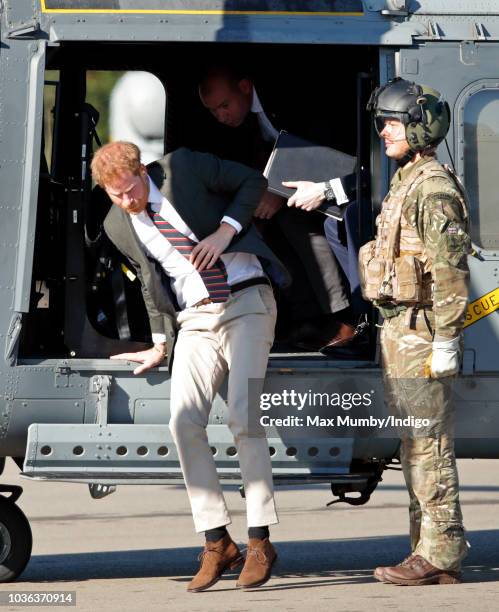 Prince Harry, Duke of Sussex disembarks a Royal Navy Wildcat Maritime Attack Helicopter as he arrives for a visit to The Royal Marines Commando...