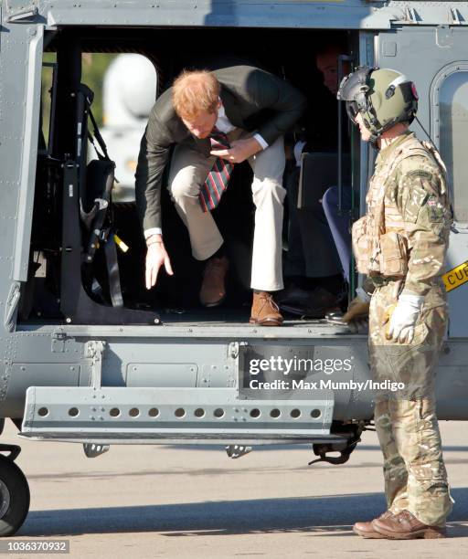 Prince Harry, Duke of Sussex disembarks a Royal Navy Wildcat Maritime Attack Helicopter as he arrives for a visit to The Royal Marines Commando...