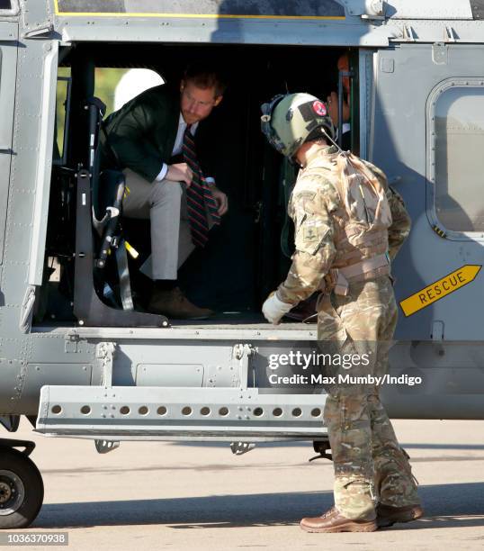 Prince Harry, Duke of Sussex disembarks a Royal Navy Wildcat Maritime Attack Helicopter as he arrives for a visit to The Royal Marines Commando...