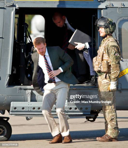 Prince Harry, Duke of Sussex disembarks a Royal Navy Wildcat Maritime Attack Helicopter as he arrives for a visit to The Royal Marines Commando...