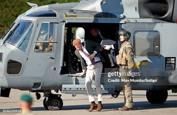 Prince Harry, Duke of Sussex disembarks a Royal Navy Wildcat Maritime Attack Helicopter as he arrives for a visit to The Royal Marines Commando...