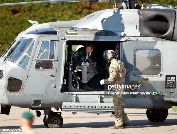 Prince Harry, Duke of Sussex disembarks a Royal Navy Wildcat Maritime Attack Helicopter as he arrives for a visit to The Royal Marines Commando...