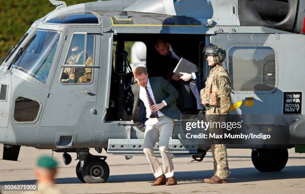 Prince Harry, Duke of Sussex disembarks a Royal Navy Wildcat Maritime Attack Helicopter as he arrives for a visit to The Royal Marines Commando...