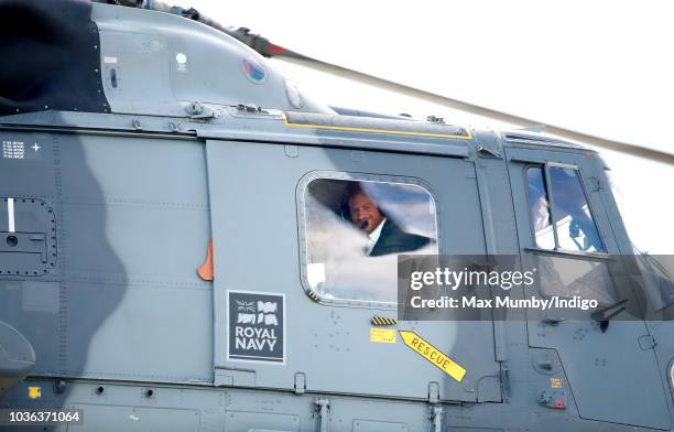 Prince Harry, Duke of Sussex looks out of the window of a Royal Navy Wildcat Maritime Attack Helicopter as departs The Royal Marines Commando...