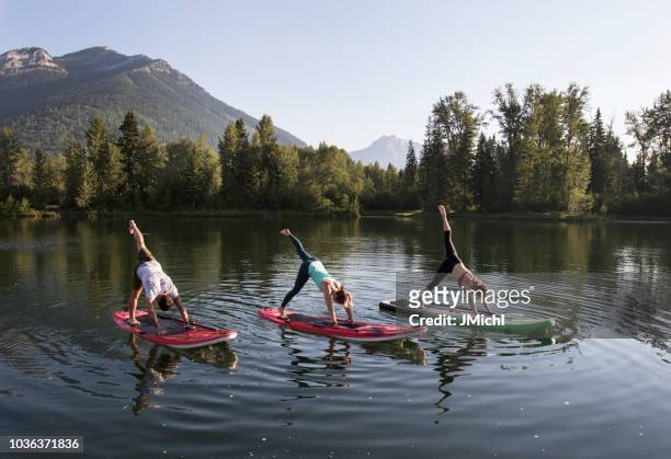 paddle board yoga - yoga retreat stock pictures, royalty-free photos & images