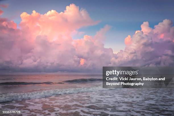 sea foam and pink puffy clouds at sunrise on myrtle beach, south carolina - pink sky stock pictures, royalty-free photos & images