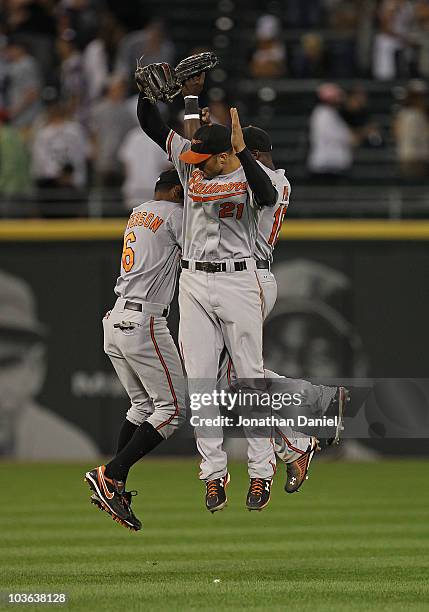 Cory Patterson, Nick Markakis and Felix Pie of the Baltimore Orioles leap in celebration after a win over the Chicago White Sox at U.S. Cellular...