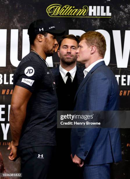 Anthony Joshua and Alexander Povetkin face off as Eddie Hearn looks on during the Anthony Joshua And Alexander Povetkin Press Conference on September...